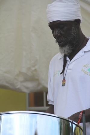 Musician and Villager Baba Tungi playing the national anthem on his steel pan  