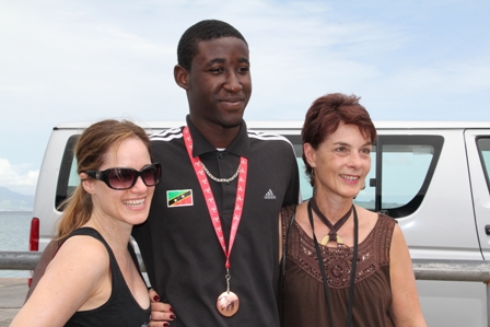 American visitors to Nevis (L-R) Chantal and Maria eager to share the moment with Adrian Williams on his return to Nevis following his bronze medal win at the Commonwealth Youth Games in the Isle of Man