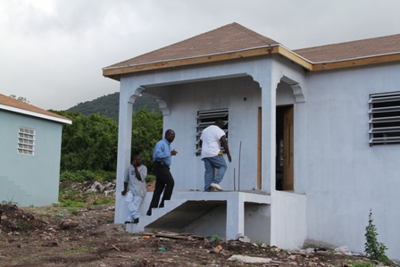 A frontal view of the new Petal design one bedroom home at the Nevis Housing and Land Development Corporation’s Sugar Mill Housing Development at Hamilton. The Corporation’s Chairman Hon. Robelto Hector accompanying Contractor Mr. Trevor Sutton into the building