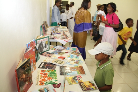 Reading books on display in the new Cotton Ground Community Centre attracts a youngster while villagers tour the facility