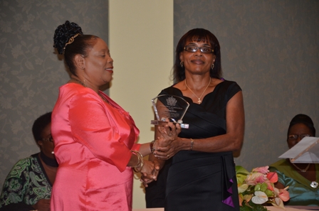 Mrs. Lineth Williams of the Gingerland High School receives plaque from Mrs. Sonita Daniel wife of Deputy Premier Hon. Hensley Daniel 