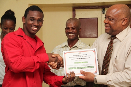 A beaming participant Mr. Eugene Weekes of Hamilton Village receives his Certificate of Achievement from Social Development Minister Hon. Hensley Daniel