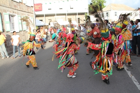 Young Masqueraders dance to the beat of the Big Drum as they entertain those present at the official opening of Tourism Week 2012 in Charlestown