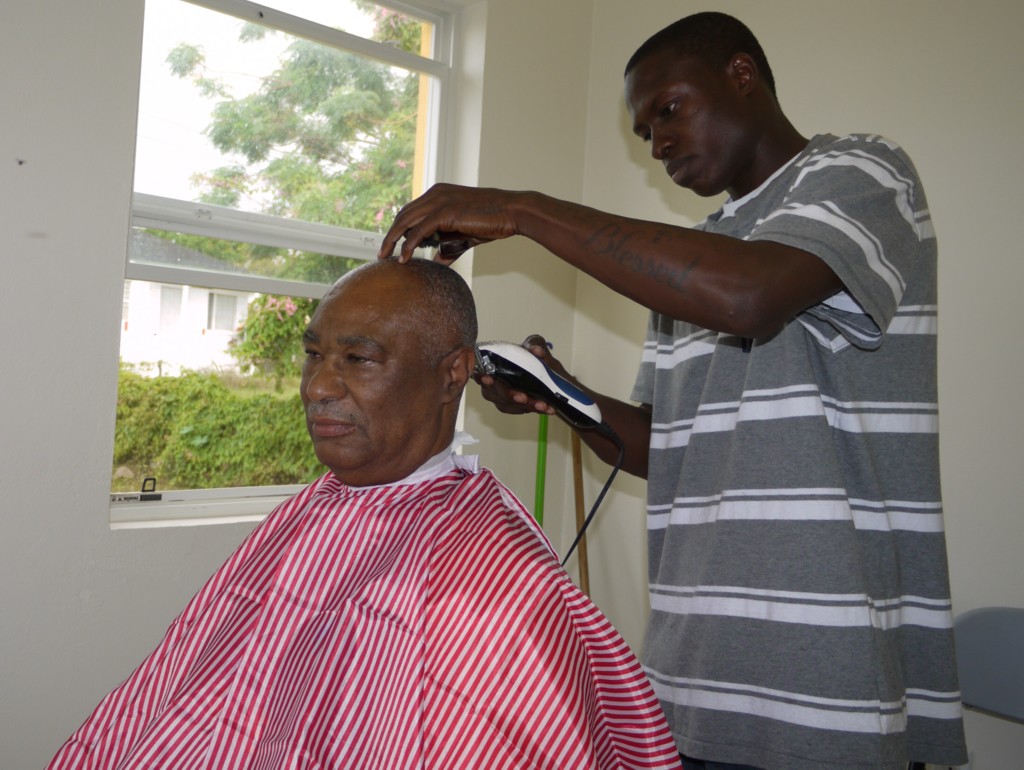 Nevis Premier Honourable Joseph Parry receives a haircut from Mr. Analdo Browne of Fresh Look Beauty Salon and Barber'n