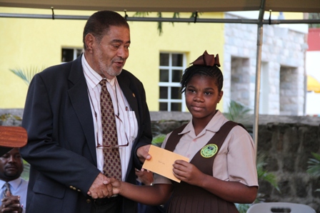 Deputy Governor General His Honour Eustace John presents Alexander Hamilton Scholarship package to Ms. Clarisa Dore of the Gingerland Secondary School