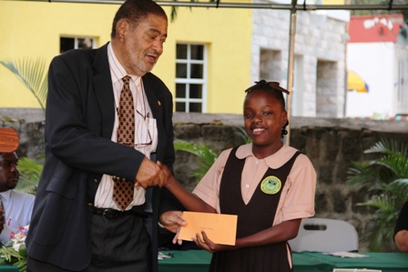  Deputy Governor General His Honour Eustace John presents Alexander Hamilton Scholarship package to Ms. Shadae Stanley of the Gingerland Secondary School