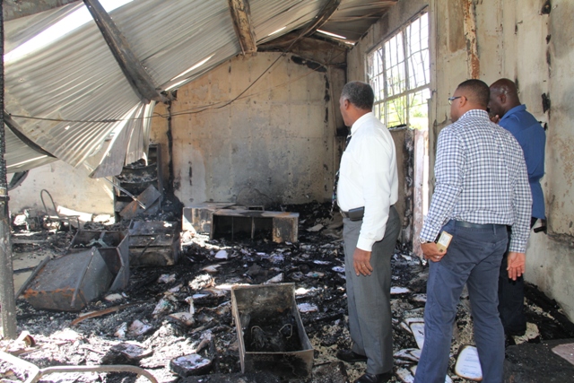 Members of the Nevis Island Cabinet looking at the burnt out Treasury Building