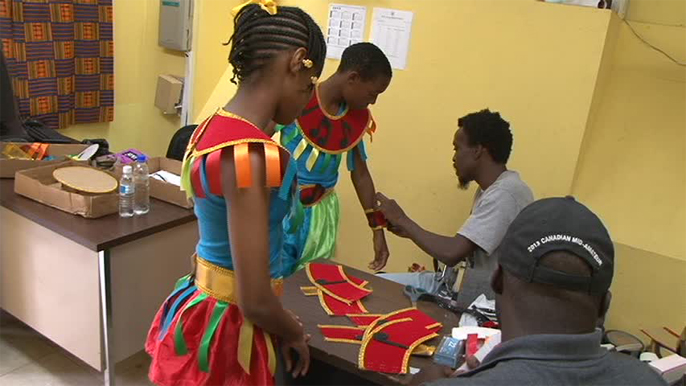 Students being fitted with costumes tailored by Banker’s Mas Camp at the Culturama Secretariat on June 04, 2014
