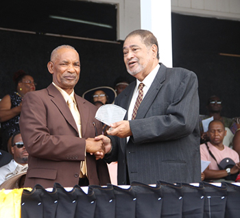 Aubrey Jones receives an award from His Honour Eustace John Deputy Governor General for his services in Industry and Commerce