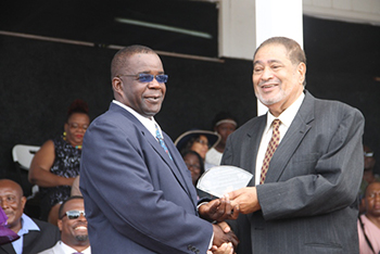 Livingstone Lawrence receives an award from His Honour Eustace John Deputy Governor General for his services in Sports