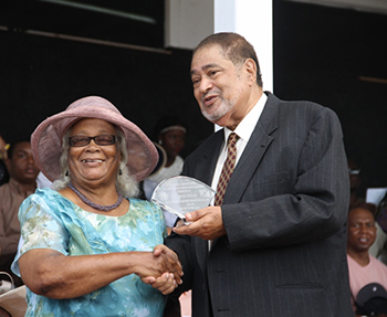 Norah Mulrain receives an award from His Honour Eustace John Deputy Governor General for her services in Health