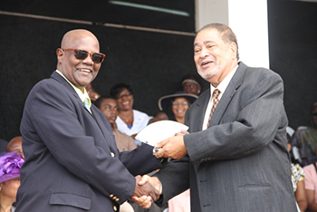 Tyrone O’Flaherty receives an award from His Honour Eustace John Deputy Governor General for his services in Culture