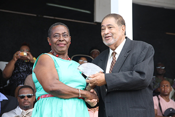 Lornette Thompson receives an award from His Honour Eustace John Deputy Governor General for her services in Public Service