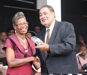 Myrna Webbe receives an award from His Honour Eustace John Deputy Governor General for her services in Health