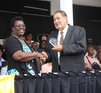 Lucia Wilkinson receives an award from His Honour Eustace John Deputy Governor General for her services in Education