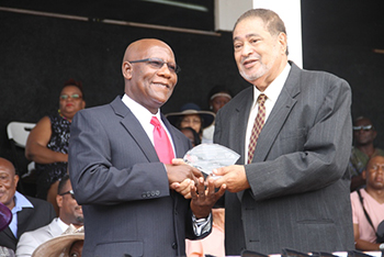 Stedroy Williams receives an award from His Honour Eustace John Deputy Governor General for his services in Health