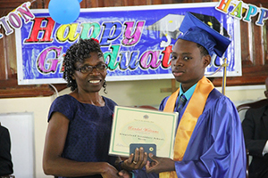 Gingerland Secondary School’s 2014 Caribbean Certificate of Secondary Level Competence examinations Valedictorian Randal Williams, receives his certificate from Patron, Jennifer Liburd, at the School’s 41st Graduation Ceremony at the Gingerland Methodist Church on November 27, 2014