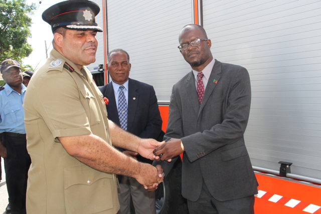 Acting Fire Chief Everette O’Garro receives keys to the new fire tender from Federal Minister of Homeland Security Hon. Patrice Nisbett at the Charlestown Fire Station on December 17, 2014. Premier of Nevis Hon Vance Amory looks on