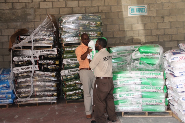 Supply Office Manager Ricky Liburd assists a customer with a bag of dog feed on January 06, 2015
