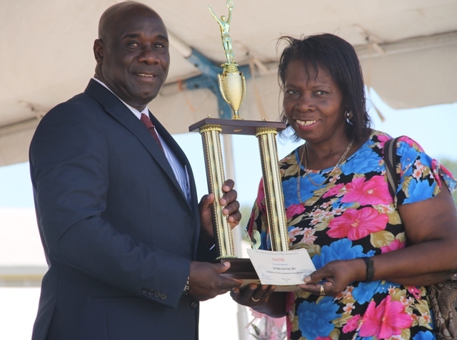 A family member of Top fisher in Nevis for 2014 Ehud Mills receives the Department of Agriculture award, on his behalf, from Minister of Agriculture Hon. Alexis Jeffersat the 21st Annual open Day hosted by the Department of Agriculture