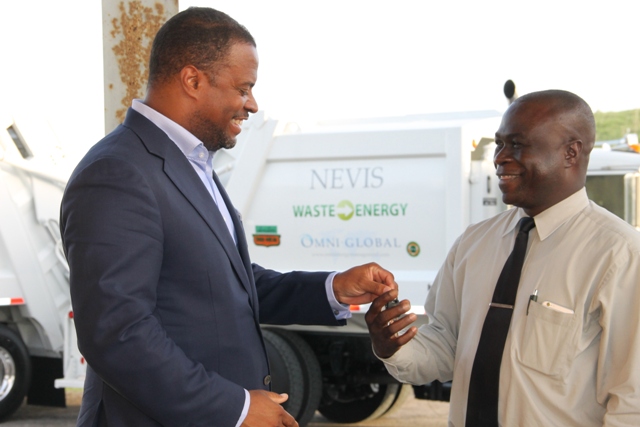Deputy Premier and Minister of Health on Nevis Mark Brantley hands over keys to two state-of-the-art Kenworth garbage collection trucks to General Manager of the Nevis Solid Waste Management Authority Andrew Hendrickson at a handing over ceremony at the Long Point landfill on September 17, 2015