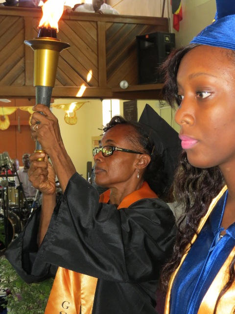 Derez Morton Valedictorian of the Gingerland Secondary School’s Graduating Class of 2015 awaits the torch from Deputy Principle Lineth Williams at the 42nd annual Graduation Ceremony at the Gingerland Methodist Church on November 12, 2015