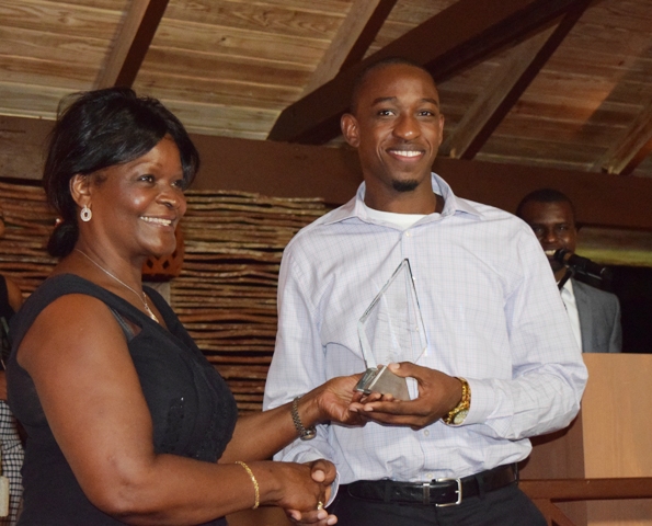The Above and Beyond Award being presented to Jevon Claxton on behalf of Craig David by Premier of Nevis Hon. Vance Amory’s wife Mrs. Verni Amory, at the first IT Delta Awards on December 19, 2015, at the Nisbet Plantation Inn