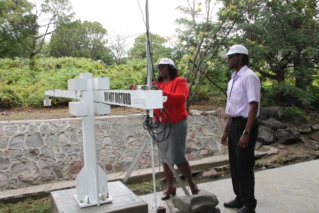 Personnel from the Nevis Disaster Management Department (l-r) Gracelyn Elliott, Community Liaison Officer and Jamal Jean-Jacques of the Communications Unit checking the flood level recorder at Bath Stream on April 06, 2016. The equipment is a part of the United States Agency for International Development-funded early flood warning project on Nevis