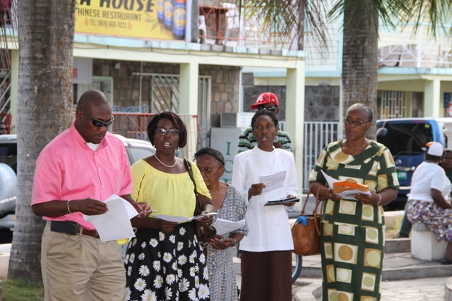 Brian Dyer, Director of the Nevis Disaster Management Department (extreme left) and Preacher Rev. Careen White-Richardson (second from right) join in song with other members of the community at the Nevis Christian Council’s prayer service for God’s protection during the 2016 hurricane season at the War Memorial Square in Charlestown on June 17, 2016