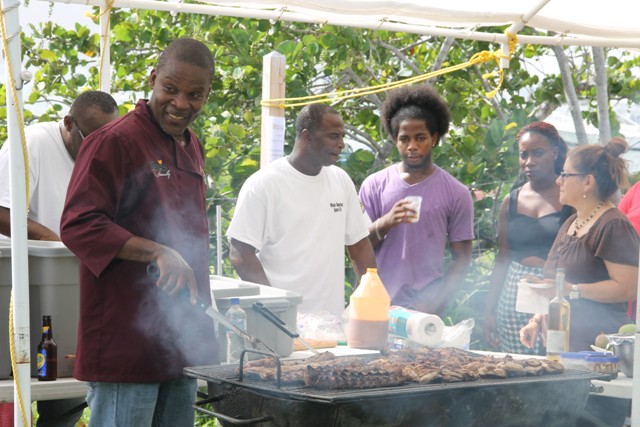 Local chef Franklyn “Cut” Daniel from the Nevis Water Department Sports Club barbecuing with his special mango sauce at the Nevisian Chefs Mango Feast at Oualie Beach during the third annual Nevis Mango and Food Festival