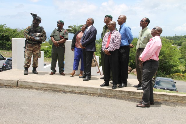 Nevis Island Administration officials witness a demonstration with drones by personnel from the Reserve Corps of the St. Kitts-Nevis Defence Force during a demonstration of crime fighting skills at a training camp at the Elizabeth Pemberton Primary School at Cole Hill on August 25, 2016. (Left-right back row) Drone technician, Captain Winslow Brookes, Principal of the Elizabeth Pemberton Primary School Shenelle Pemberton, Premier of Nevis Hon. Vance Amory, Commander of the St. Kitts-Nevis Defence Force Lieutenant Colonel Patrick Wallace, Cabinet Secretary Stedmond Tross, and Assistant Secretary in the Premier’s Ministry Kevin Barrett. (Front row l-r) Permanent Secretary in the Premier’s Ministry Wakely Daniel and Hon. Alexis Jeffers
