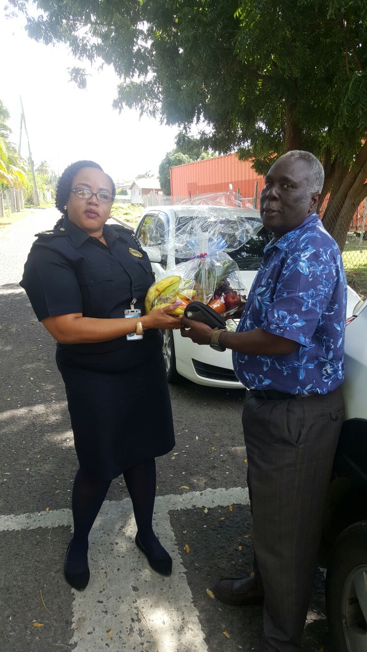 Wendy Wilkes, Senior Customs Officer at the Customs and Excise Department on Nevis presents a fruit basket to Stephen Jones, a past customs officer as a token of appreciation from the department on International Customs Day on January 26, 2017