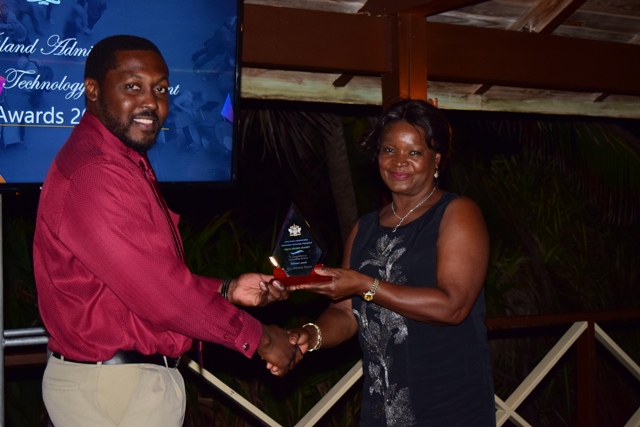 Craig David, Assistant Director at the Information Technology Department in the Nevis Island Administration, receiving the Ticketeer Award on behalf of Vanessa Tyson from Mrs. Verni Amory, wife of the Premier of Nevis Hon. Vance Amory, at the 2nd Annual Information Technology Department Delta Awards Dinner at the Nisbet Plantation Beach Hotel on February 18, 2017