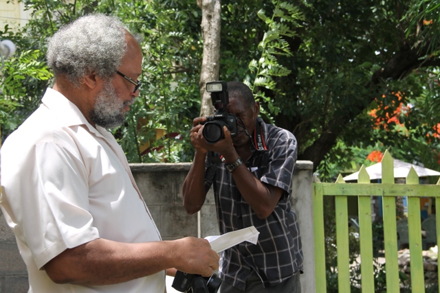 Dr. Whitman Browne, Nevisian author of three publications on the M.V, Christena Disaster in St. Kitts and Nevis in 1970, takes a picture of Lester Blackett while collecting photographs at the Memorial Service at the Alexander Hamilton Museum Grounds on August 01, 2017, commemorating the 47th anniversary of the disaster