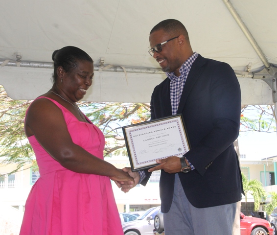 Minister of Health Hon. Mark Brantley presents a plaque to Nurse Manager Laurel Smithen on behalf of the Alexandra Hospital at their Pre-Christmas Programme on December 13, 2017, for her dedication to Nursing
