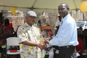 Mr. John Hanley, Acting Permanent Secretary in the Ministry of Tourism (left) presenting an award to Mr. Theodore Kelly in recognition of his 15 years of service at the Nevisian Heritage Village in Gingerland at the 15th anniversary celebration on February 22, 2018