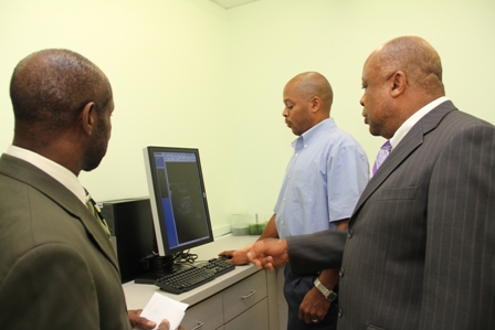 Gary Pemberton a Radiographer at the Radiology Department, Alexandra Hospital shows some of the Picture Archiving and Communication System (PACS) equipment from the Social security Board to (L-R) Deputy Prime Minister and Federal Minister for Social Security Hon. Sam Condor and Deputy Premier of Nevis and Minister of Health Hon. Hensley Daniel