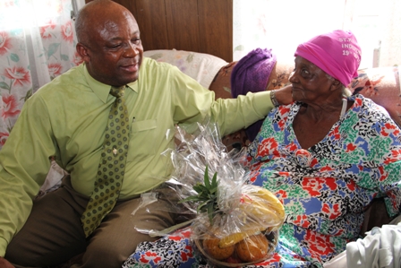 Minister of Social Development, the Ministry responsible for the care and wellbeing of senior citizens on Nevis Hon. Hensley Daniel caringly presents 85-year old Birthday Celebrant Ms. Eulalie Brown with a fruit basket at her home in Brown Hill Village. Prior to taking up residence at Brown Hill Ms. Brown was a long time resident of Brown Pasture Village
