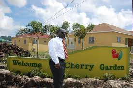 Cherry Gardens Affordable Housing with Director of Land and Housing Mr.Eustace Nisbett standing in front of the property.