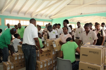 Students at the Gingerland Secondary School line up to receive their laptops