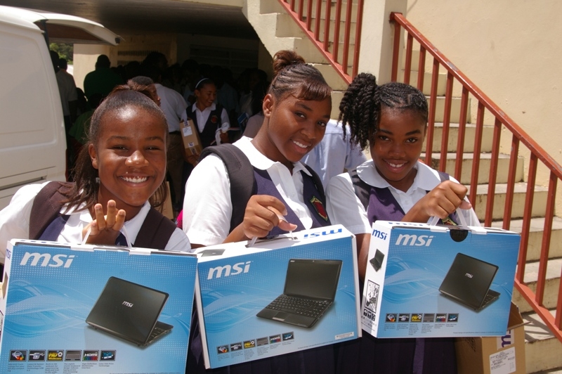 Charlestown Secondary School girls- Jazzee Connor, Ann Bussue and Jade Slack holding their laptops