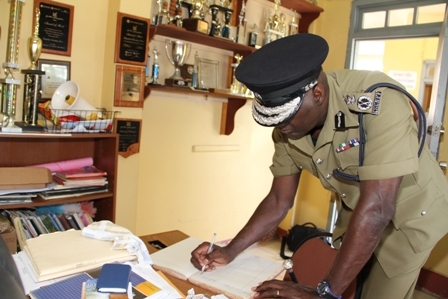 Commissioner of Police in the Royal St. Christopher and Nevis Police Force Celvin G. Walwyn signing the Visitor’s Book at the Gingerland Secondary School