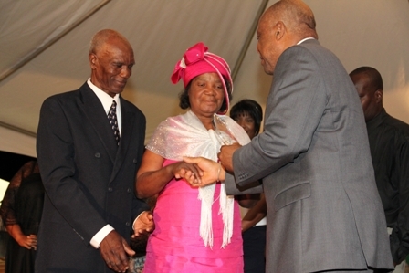 Minister of Culture presents a plaque to Mr. and Mrs. Cecil Sutton the parents of Mr. Michael Herald Sutton and other family members moments before his name was unveiled on the Nevis Performing Arts centre’s auditorium