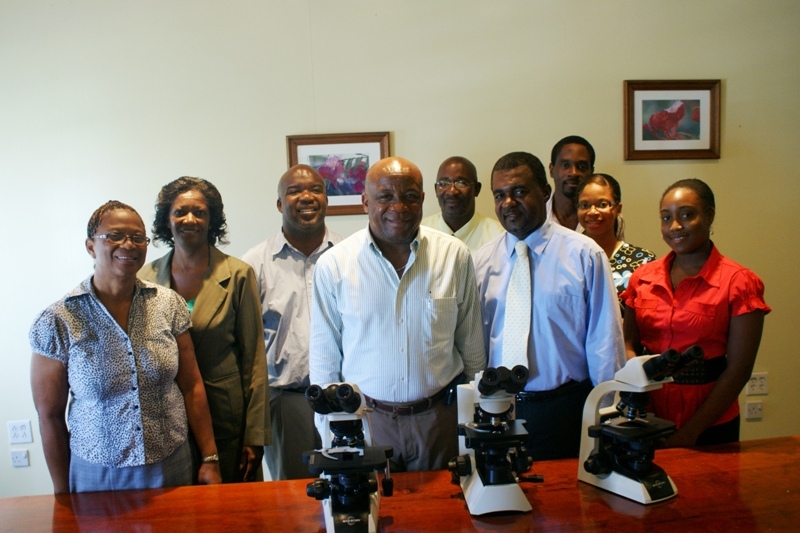 (L-R) Seven Day Adventist Board Member Mrs. Verina William, Permanent secretary in the Ministry of health Ms. Angelica Elliott, Medical Lab Supervisor Mr. Clester Roberts, Minister of Health on Nevis Hon. Hensley Daniel, Pastor of the Charlestown Seven Day Adventist Church in Charlestown Jerry Languedoc, Acting Hospital Administrator Mr. Johnson Morton and other Lab staff at the handing over ceremony of three microscopes to the Alexandra Hospital’s Lab from the SDA