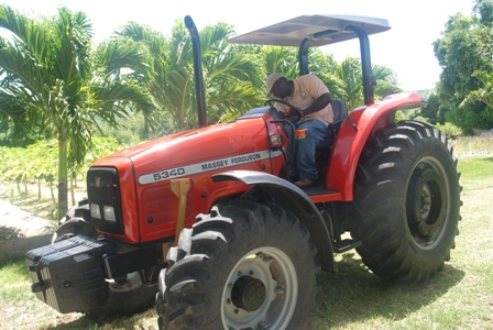 A member of staff of the Department of Agriculture on Nevis trying out the US$38,500 Massey Ferguson tractor, a gift from the Government of the Republic of China/Taiwan for use by the Department in its land preparation programme