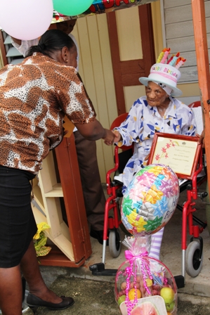 Director of Social Services Ms. Sandra Maynard making presentations to birthday girl Mrs. Selina Ward during her 101 birthday celebrations