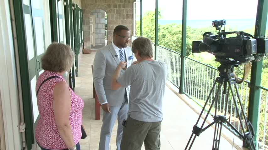 Veteran Photographer and Cameraman Bob Oliver readies Deputy Premier of Nevis and Minister of Tourism Hon. Mark Brantley for an interview with Producer of Boston’s acclaimed Chronicle programme Maggie Harper at Bath Hotel