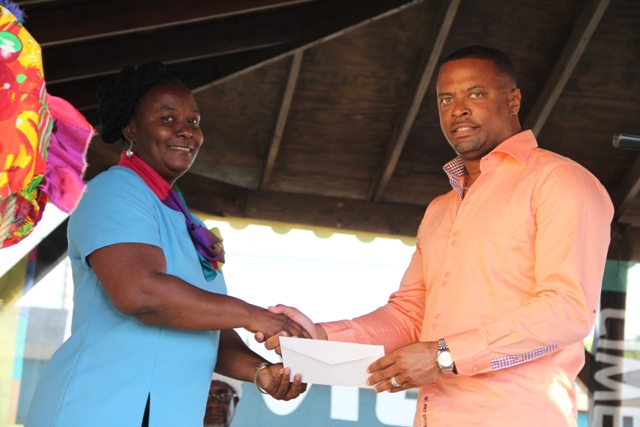 Deputy Premier and Minister of Culture on Nevis, Hon. Mark Brantley accepts $250,000 donation from Lornette Powell, representative of LIME, the platinum sponsor for Culturama 40