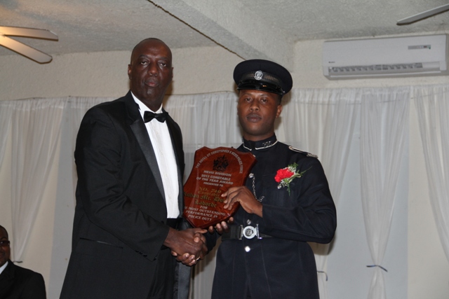 Commissioner of the Royal St. Christopher and Nevis Police Force Celvin Walwyn hands over the plaque to Constable of the Year for 2013 Rohan Laborde at the Police Constable Awards Ceremony and Dinner at the Occasions Entertainment Arcade on March 01, 2014