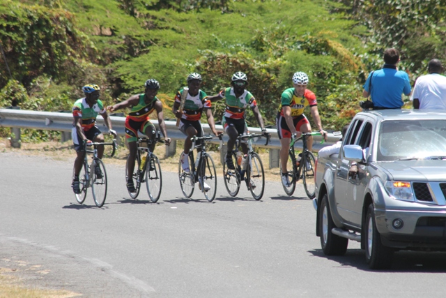 Members of the Nevis Cycle & Triathlon Club help to carry the Queen’s Baton around the island of Nevis on March 29, 2014